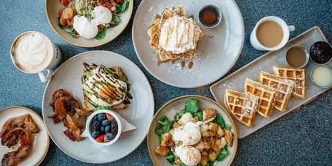 A cosy cafe table with fresh pancakes, coffee, and fruit served for breakfast